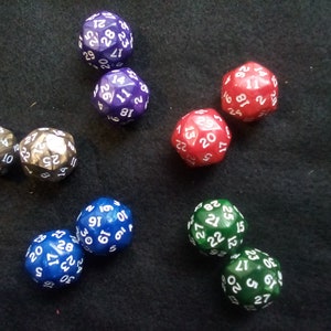 May include: A collection of ten-sided dice in various colors, including purple, silver, red, blue, and green. The dice are numbered 1 through 20.