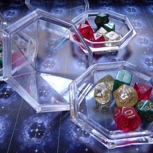 May include: A set of six clear plastic dice trays with a variety of colorful dice inside. The dice are red, green, and gold with black numbers.