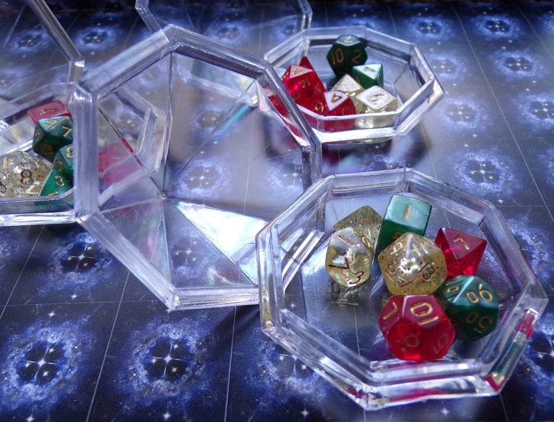 May include: A set of six clear plastic dice trays with a variety of colorful dice inside. The dice are red, green, and gold with black numbers.