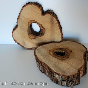 May include: Two natural wood slices with bark edges and a hole in the centre. The slices are stacked on top of each other.  Modèle F 13-15 x 2 1/2 ou 3po