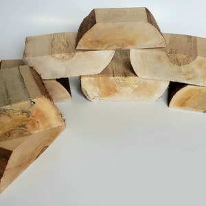 May include: A set of six wooden blocks, each with a unique curved shape. The blocks are made of light brown wood and have a natural, rustic finish.