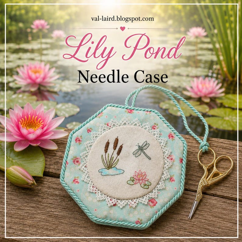 May include: A hexagonal needle case with a light blue floral fabric base, featuring a central cream-colored circular patch embroidered with cattails, a dragonfly, and a water lily. A gold-toned pair of scissors is attached by a light blue cord.