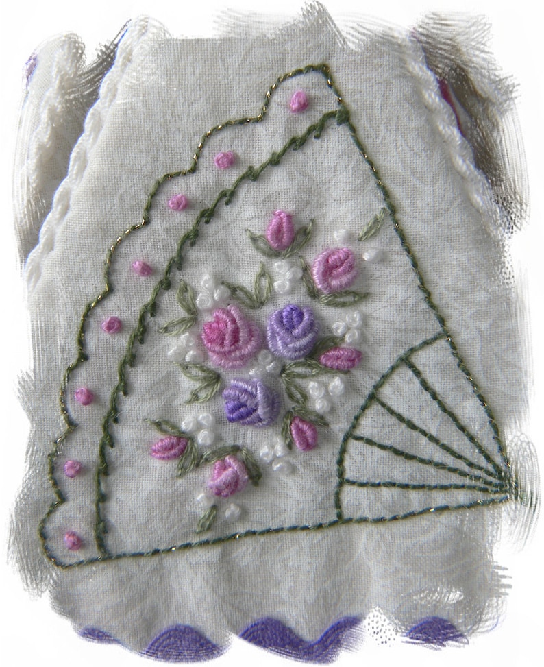 May include: A white fabric handkerchief with a delicate floral embroidery design. The embroidery features pink, purple, and white flowers with green leaves. The handkerchief has a scalloped edge.