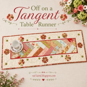 May include: A rectangular quilted table runner featuring a central herringbone pattern of floral fabric strips in red, green, and cream. The border is cream with appliqued fabric flowers and green buttons. A white teacup sits on the runner.