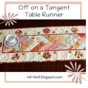 May include: A white table runner with a patchwork design of red, pink, green and blue floral fabric. The runner has a scalloped edge and is decorated with embroidered flowers and green leaves. The text "Off on a Tangent Table Runner" is displayed above the runner. The website address "val-laird.blogspot.com" is displayed below the runner.