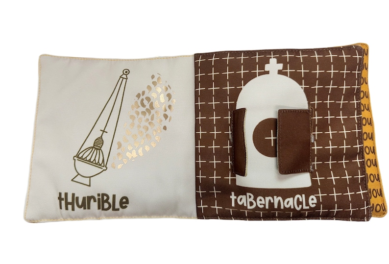 以下が含まれることがあります： 2 ページ開きの布製本。片方のページには、単語「tHuriBlE」が付いた金色の香炉のイラストが描かれています。もう一方のページには、単語「taBERNACLE」が付いた幕屋のイラストが描かれています。背景は白十字の茶色です。