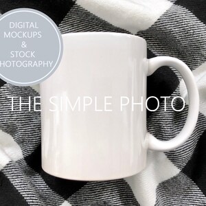 May include: White ceramic coffee mug with a handle, sitting on a black and white checkered fabric. The mug is blank and ready for customization. The text "THE SIMPLE PHOTO" is visible on the mug.
