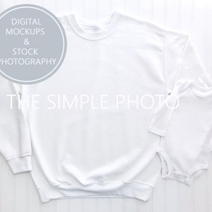 May include: White long-sleeve sweatshirt and white bodysuit mockup on a white wood background. The text "DIGITAL MOCKUPS & STOCK PHOTOGRAPHY" is in a circle on the top left corner of the image. The text "THE SIMPLE PHOTO" is in the center of the image.