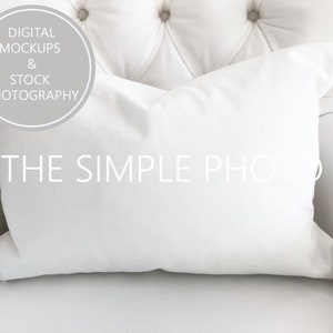 Könnte beinhalten: Ein weißes Kissen auf einem weißen, gesteppten Sessel. Das Kissen ist leer und bereit für die Personalisierung. Der Text "THE SIMPLE PHOTO" ist auf dem Kissen sichtbar.