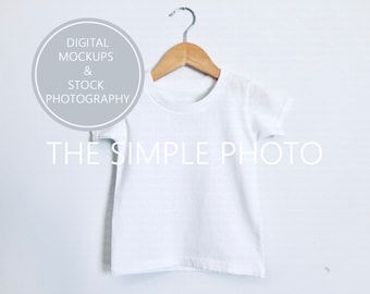 Camiseta para niños pequeños Mockup, camiseta blanca Mockup, Mockup camisa para niños, camiseta de la foto de la acción, camisa de niño con estilo, camisa en el colgador, mockup de los niños