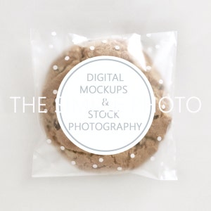 May include: A close-up of a chocolate chip cookie in a clear plastic bag with white polka dots. The bag has a white circle sticker with the text "DIGITAL MOCKUPS & STOCK PHOTOGRAPHY" in gray text.