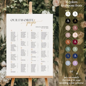 May include: A wedding seating chart on a wooden easel. The chart is white with gold lettering that reads "Our Favorite People" and lists names alphabetically. Sixteen color options are shown. The chart is for Grace & Benjamin, 10.22.202X.
