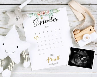 May include: A white calendar with the month of September 2024 highlighted. A gold heart is circled on the 1st. The text "BABY Powell DUE TO ARRIVE" is at the bottom of the calendar.