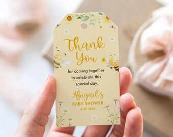 Puede incluir: Una etiqueta de agradecimiento amarilla con un diseño de abeja y flores. El texto dice "Gracias" por venir a celebrar este día especial. Baby Shower de Abigail 9.27.20XX