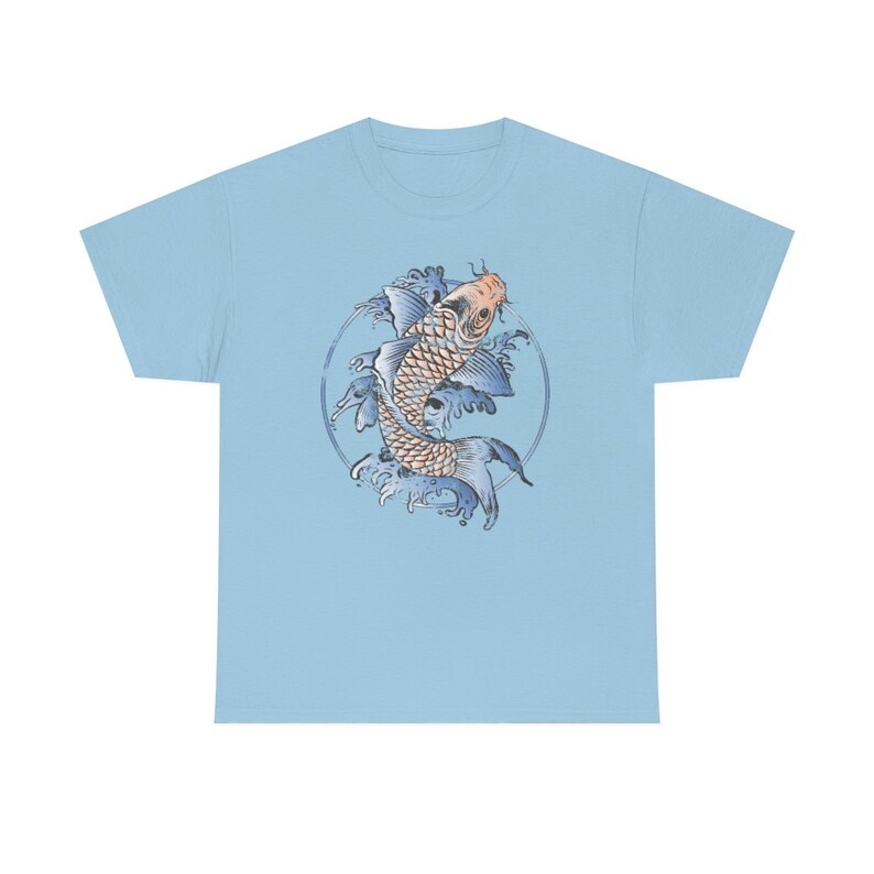 May include: A light blue t-shirt with a graphic of a blue and orange koi fish swimming in a circle of blue waves.