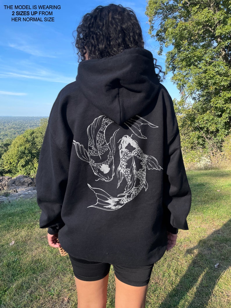 May include: Black hooded sweatshirt with a white graphic print of two koi fish swimming in a circle on the back.