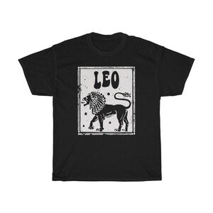 K&ouml;nnte beinhalten: Schwarzes T-Shirt mit einer wei&szlig;en Grafik eines L&ouml;wen und dem Wort "LEO" in einer Retro-Schrift.
