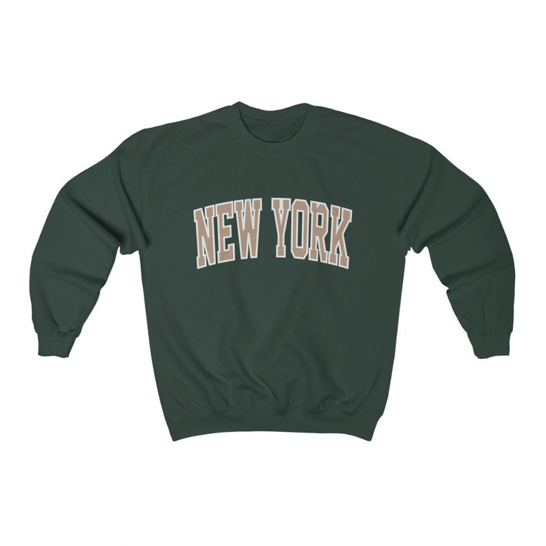 May include: A dark green sweatshirt with the text "NEW YORK" in a beige color.