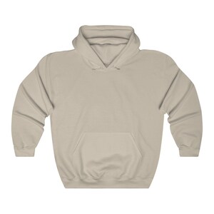 May include: A plain, light beige hoodie with a pouch pocket on the front. The hoodie has a drawstring hood.