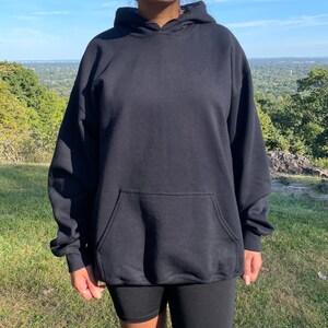 Puede incluir: Una sudadera con capucha negra con un bolsillo canguro. La sudadera est&aacute; hecha de una tela suave y c&oacute;moda y tiene un corte holgado.