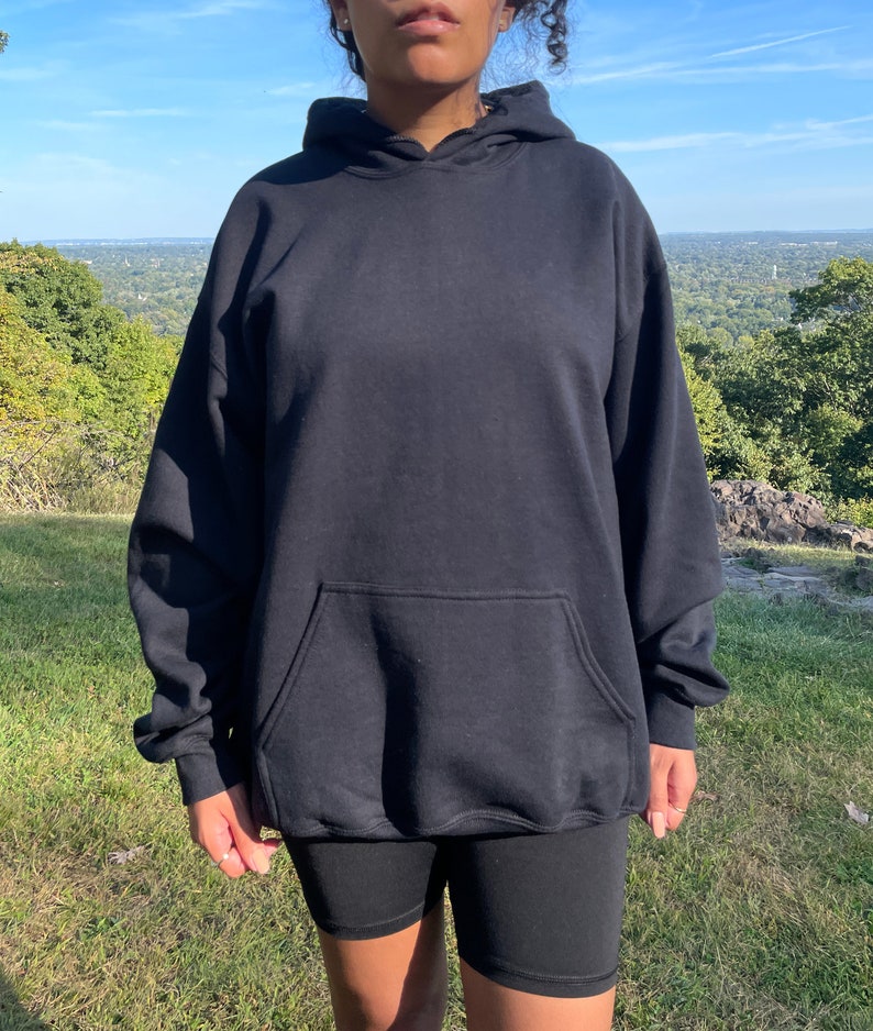 Puede incluir: Una sudadera con capucha negra con un bolsillo canguro. La sudadera est&aacute; hecha de una tela suave y c&oacute;moda y tiene un corte holgado.