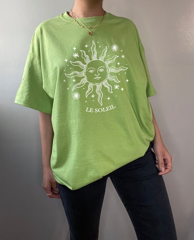 May include: A lime green t-shirt with a white sun and stars graphic and the text "LE SOLEIL".
