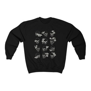 K&ouml;nnte beinhalten: Schwarzer Pullover mit einem wei&szlig;en Druck von mehreren Sch&auml;deln mit Blumen und Schmetterlingen.