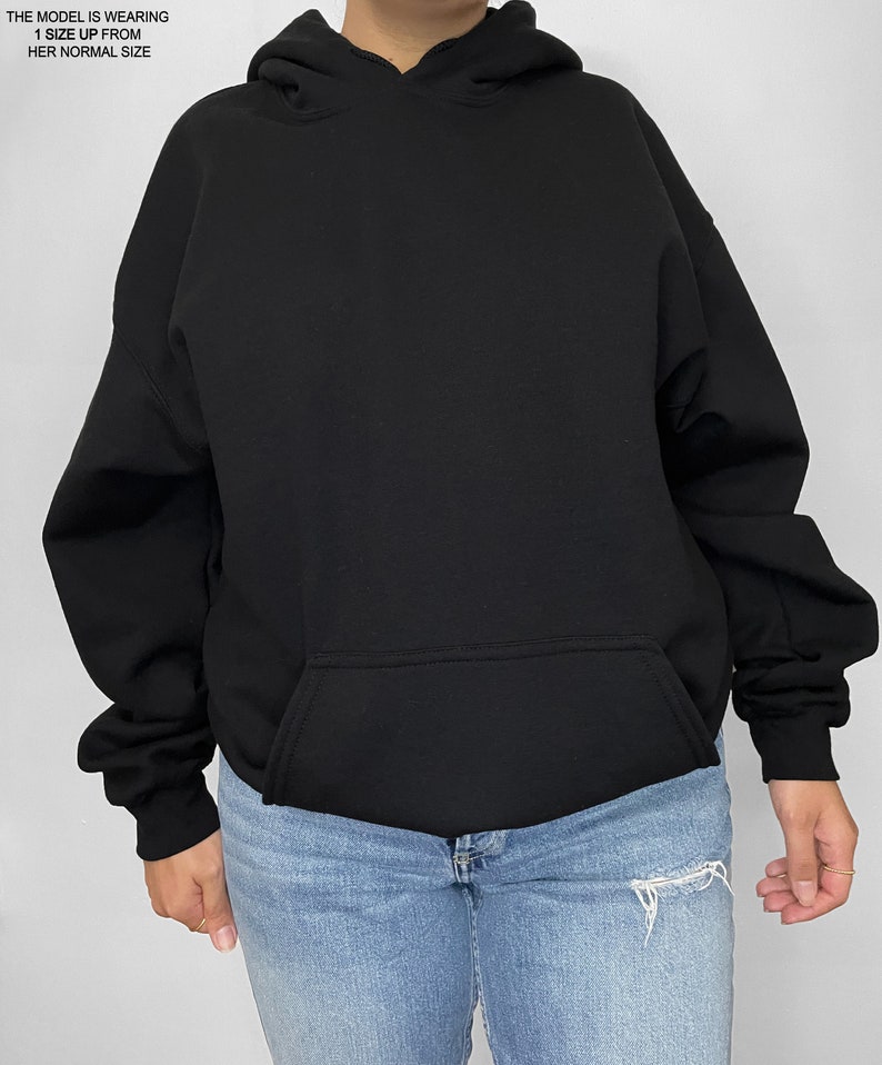 May include: Black oversized hoodie with a kangaroo pocket. The model is wearing a size up from their normal size.