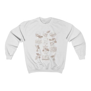 May include: White sweatshirt with a brown outline design of skulls, books, flowers, and other decorative elements.