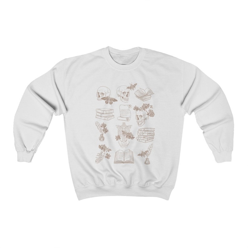 May include: White sweatshirt with a brown outline design of skulls, books, flowers, and other decorative elements.