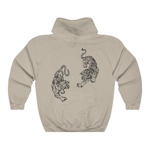 May include: A beige hooded sweatshirt with a black graphic of two tigers facing each other.