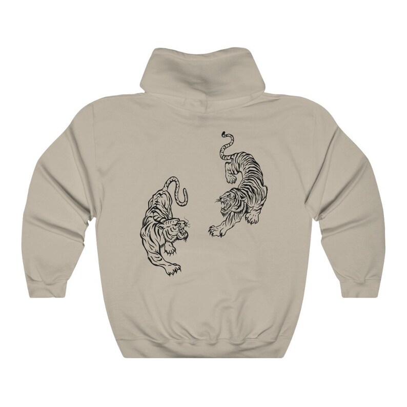 May include: A beige hooded sweatshirt with a black graphic of two tigers facing each other.