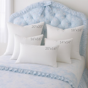 May include: A collection of white pillows in various sizes, including 20x20 inches, 16x16 inches, 14x14 inches, 20x14 inches, and 18x18 inches. The pillows are arranged on a bed with a light blue floral patterned headboard and bedding.