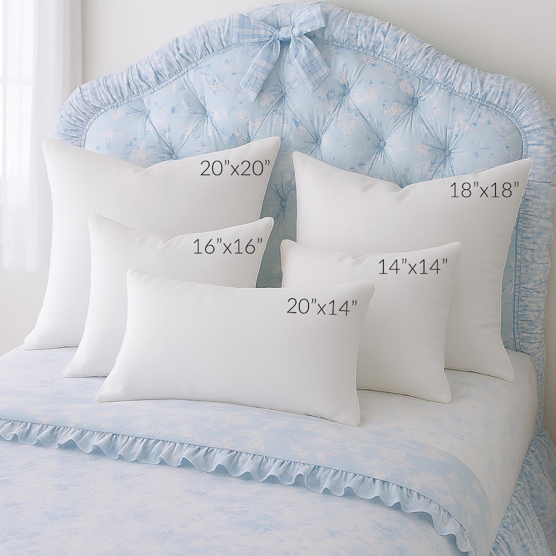 May include: A collection of white pillows in various sizes, including 20x20 inches, 16x16 inches, 14x14 inches, 20x14 inches, and 18x18 inches. The pillows are arranged on a bed with a light blue floral patterned headboard and bedding.