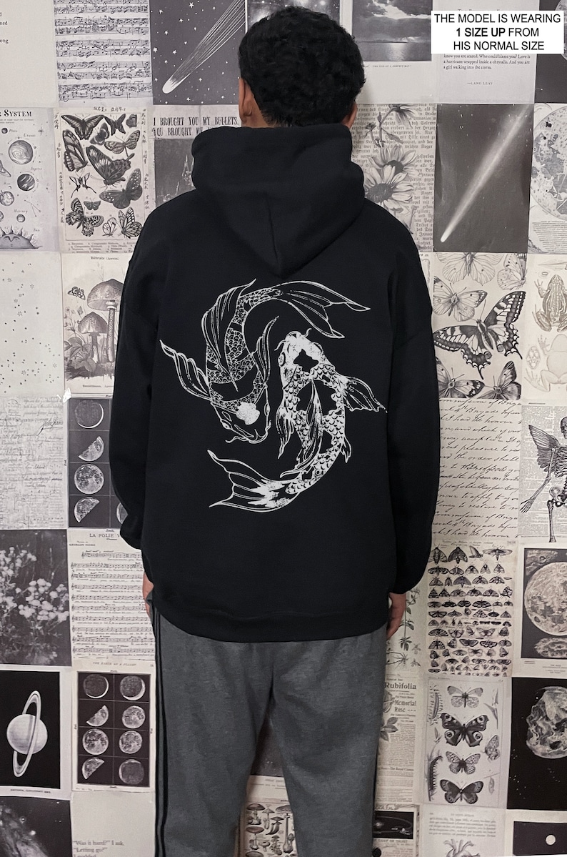 May include: Black hoodie with a white graphic of two koi fish swimming in a circle. The model is wearing a size up from their normal size.