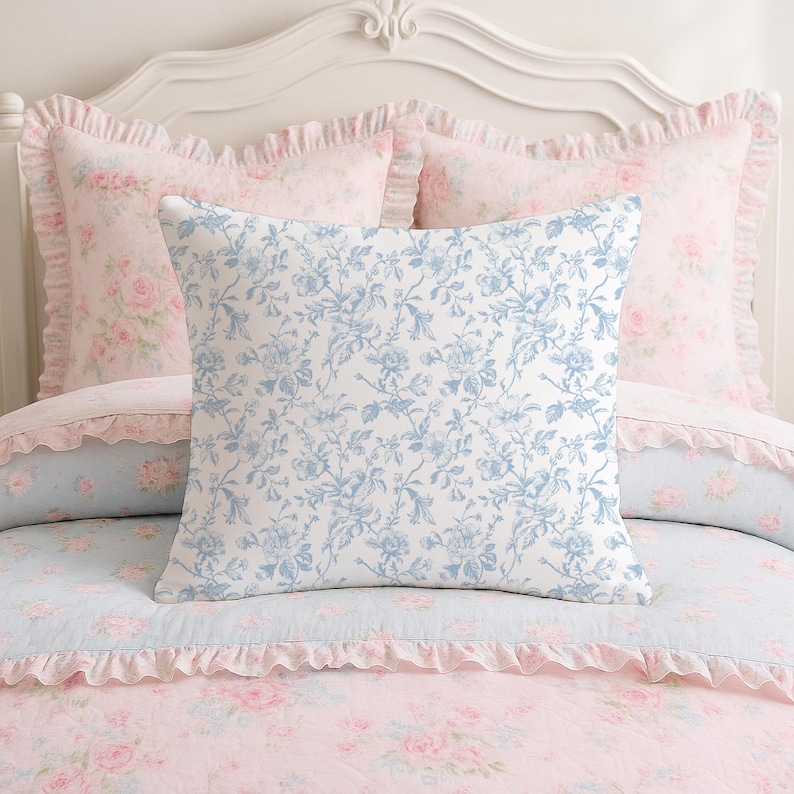 May include: A bed with a white headboard and floral bedding. The bedding includes a square pillow with a blue floral pattern, and pink pillows with ruffled edges. The comforter is pink with a floral pattern.