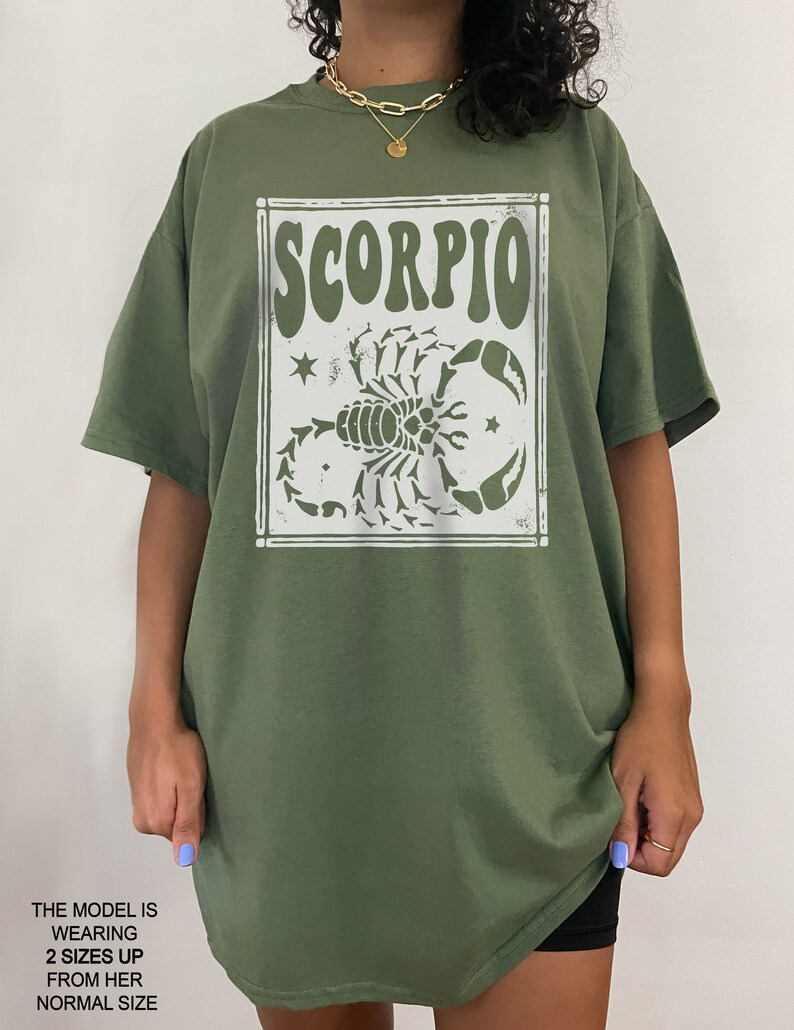 May include: Green t-shirt with a white graphic of a scorpion and the word "SCORPIO" in a retro font.