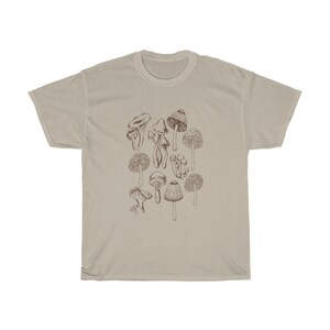May include: A beige t-shirt with a brown line drawing of various mushrooms.