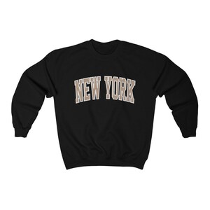 May include: Black sweatshirt with a brown "NEW YORK" graphic on the front.