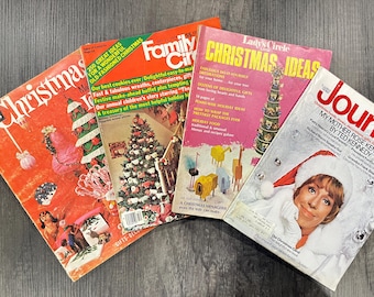 May include: A collection of vintage Christmas magazines with colorful covers. Titles include "Christmas Ideas," "Family Circle," and "Journal." The magazines feature festive imagery, including Christmas trees and holiday scenes.