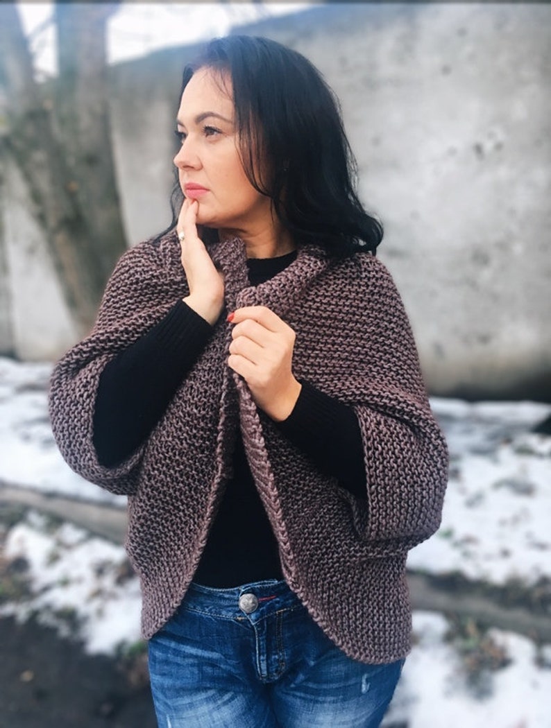 May include: A mauve knitted cardigan with a relaxed fit and long sleeves. The cardigan is open in the front and has a slightly cropped length.