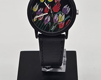 ¡El exclusivo reloj Timex vintage presenta una esfera negra decorada con tulipanes multicolores!