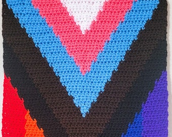May include: A crocheted rainbow wall hanging with a chevron pattern and fringe. The colours are red, orange, yellow, green, blue, indigo, and violet.