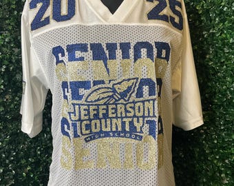 May include: White mesh jersey with gold and blue glitter lettering. The jersey says "Senior 2025 Jefferson County High School".