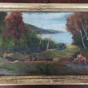 Może przedstawiać: Olejny obraz w ramie przedstawiający krajobraz z akwenem wodnym w oddali. Obraz przedstawia bujne zielone drzewa, skaliste wybrzeże i postać na pierwszym planie. Obraz jest oprawiony w złotą ramę.