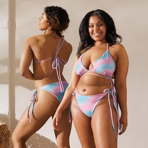 Könnte beinhalten: Zwei Frauen tragen passende Bikinis mit Batikmuster in Rosa- und Blautönen. Die Bikinis haben Dreieck-Oberteile und seitlich zu bindende Unterteile. Die Models stehen vor einem neutralen Hintergrund.