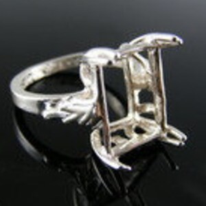 May include: Silver ring setting with a square shaped opening for a stone. The setting has a decorative design on the band.