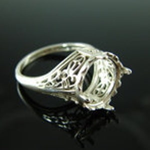 Puede incluir: Engaste de anillo de filigrana de plata con un bisel redondo para una piedra preciosa. El engaste tiene un diseño delicado e intrincado.