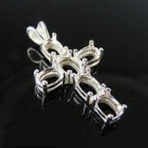 May include: Silver cross pendant with six oval-shaped settings for gemstones. The pendant has a bail for attaching to a chain.