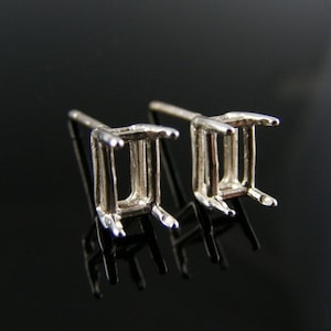 Peut inclure: Une paire de montures de boucles d'oreilles en argent avec des griffes carrées, conçues pour tenir une pierre précieuse de forme carrée.